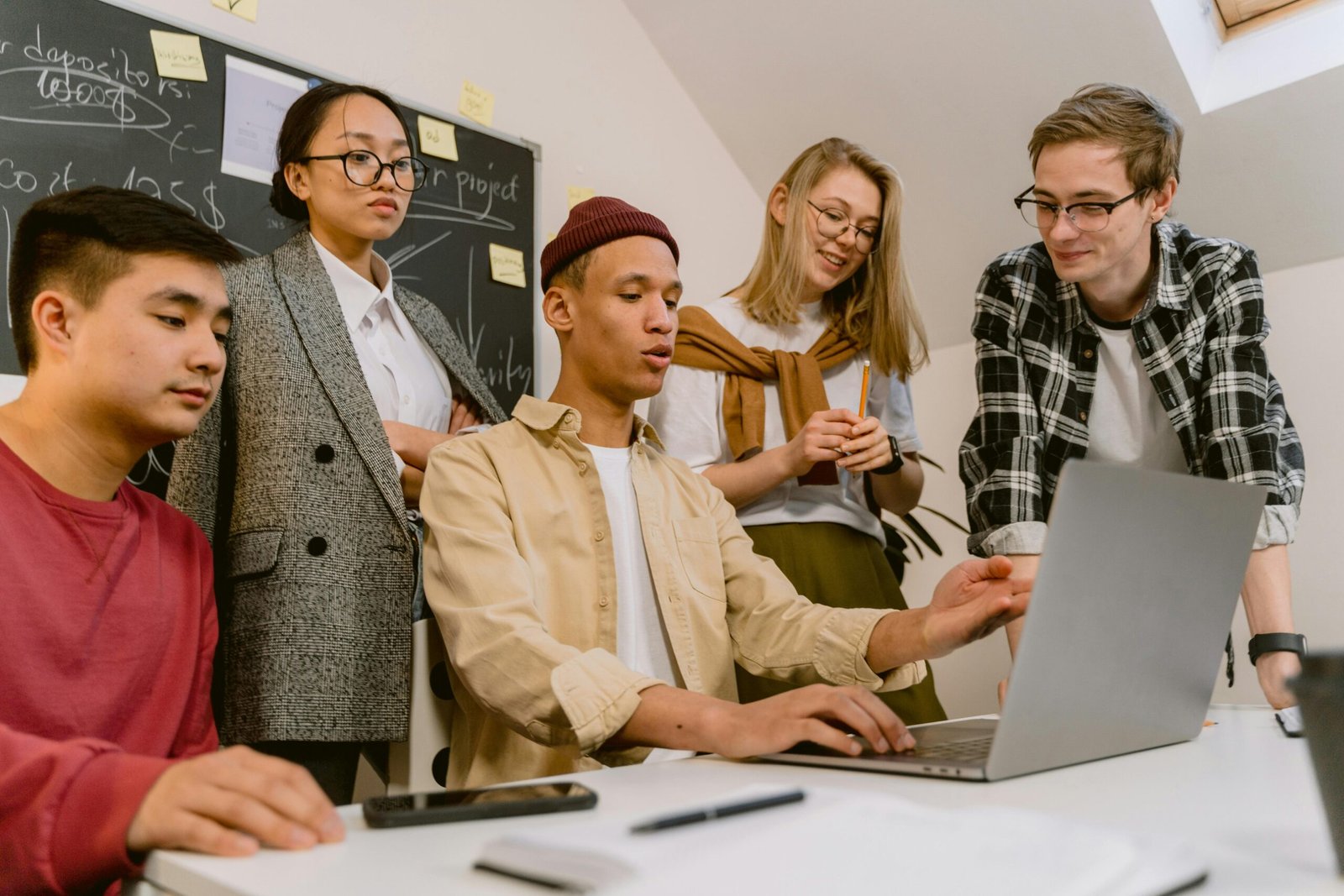 pexels-photo-6913299-6913299 A diverse team of young professionals brainstorming with a laptop in a modern office.